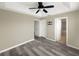 A spacious main bedroom featuring wood-look floors, neutral walls, ceiling fan, and ensuite bathroom at 4909 Terrapin Blvd, St Cloud, FL 34771