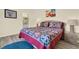 Comfortable bedroom featuring a colorful quilt and decor, with a view to the bathroom at 550 Castlemain Cir, Davenport, FL 33897