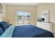 Bedroom featuring large window, wood-look floors, blue bedding and white dresser at 550 Castlemain Cir, Davenport, FL 33897