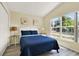 Bright bedroom with large window, wood-look floors, and coastal-themed decorations at 550 Castlemain Cir, Davenport, FL 33897