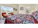 Inviting bedroom with bright window views, comfortable seating, and colorful quilt decor at 550 Castlemain Cir, Davenport, FL 33897
