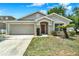 Charming single-story home with a well-manicured lawn and an attached two-car garage at 550 Castlemain Cir, Davenport, FL 33897