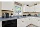 A kitchen featuring white cabinets, gray countertop, and stainless steel sink under a window at 550 Castlemain Cir, Davenport, FL 33897