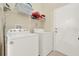 Efficient laundry room with a washer, dryer, and storage shelves for convenience at 550 Castlemain Cir, Davenport, FL 33897