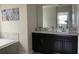 Bathroom featuring double sinks with a mirror, soaking tub, and modern finishes at 637 Ocean Course Ave, Davenport, FL 33896