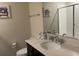 Well-lit bathroom featuring a vanity with a quartz countertop and tiled shower at 637 Ocean Course Ave, Davenport, FL 33896