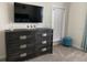 Bedroom featuring a dresser with a flat-screen TV, stool, and window with blinds at 637 Ocean Course Ave, Davenport, FL 33896