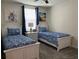 Charming bedroom featuring two twin beds with blue and white bedding and nautical-themed decor at 637 Ocean Course Ave, Davenport, FL 33896
