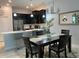 A modern dining room adjacent to the open-concept kitchen features stainless steel appliances at 637 Ocean Course Ave, Davenport, FL 33896