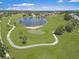 Aerial view of lush golf course with pond and scenic walking path in a beautiful community at 639 Chadbury Way, Kissimmee, FL 34744