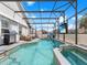 In-ground screened pool with patio seating, a grill, a TV, a basketball hoop, and partial awning at 639 Chadbury Way, Kissimmee, FL 34744