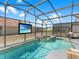 In-ground pool with spa and patio seating inside the screened pool enclosure at 639 Chadbury Way, Kissimmee, FL 34744