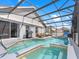 In-ground screened pool with patio seating, a grill, a basketball hoop, and partial awning for shade at 639 Chadbury Way, Kissimmee, FL 34744