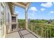 Exterior view of a sunny balcony overlooking lush greenery with railings and a view of buildings in the distance at 650 Campus St # 309, Celebration, FL 34747