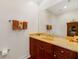Well-lit bathroom with a large mirror over a wood vanity and tan stone countertops at 650 Campus St # 309, Celebration, FL 34747