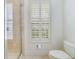 Bathroom with a glass enclosed shower, toilet and plantation shutters at 650 Campus St # 309, Celebration, FL 34747