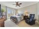 Comfortable bedroom featuring balcony access, ceiling fan, carpeted floors, and a sitting chair at 650 Campus St # 309, Celebration, FL 34747