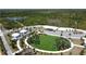 High-angle aerial view of the community recreation area with green lawn, yurts, and parking at 6514 Barnstorm Way, St Cloud, FL 34771