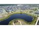 Aerial view of a community with a pond, an island with a walking trail, and meticulously maintained landscaping at 6514 Barnstorm Way, St Cloud, FL 34771