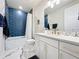 Bright bathroom featuring marble floors, white cabinets, gold hardware, and a modern blue-tiled shower-tub combination at 6514 Barnstorm Way, St Cloud, FL 34771