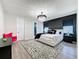 Modern bedroom features a stylish chandelier, accent wall, patterned rug, and unique decor at 6514 Barnstorm Way, St Cloud, FL 34771