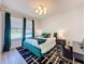 Well-lit bedroom with dark green curtains, teal accents, white walls, desk and black and white rug at 6514 Barnstorm Way, St Cloud, FL 34771