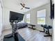 Bedroom featuring workout equipment, laminate floors, a ceiling fan and natural light from two windows at 6514 Barnstorm Way, St Cloud, FL 34771