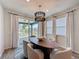 Bright dining room with designer light fixture, modern table, and sliding doors to patio at 6514 Barnstorm Way, St Cloud, FL 34771