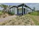 Well-maintained single-story house features a landscaped yard with green shrubs, a palm tree, and a brick walkway at 6514 Barnstorm Way, St Cloud, FL 34771