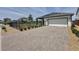 Single-Gathering home featuring a two-car garage, brick driveway, and solar panels for energy efficiency at 6514 Barnstorm Way, St Cloud, FL 34771