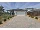 Single-Gathering home featuring a two-car garage, brick driveway, and solar panels for energy efficiency at 6514 Barnstorm Way, St Cloud, FL 34771