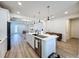 Modern kitchen with a center island and seating open to the living area featuring wood-style floors at 6514 Barnstorm Way, St Cloud, FL 34771