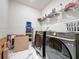 Spacious laundry room with storage, modern appliances, and marble-look tile flooring at 6514 Barnstorm Way, St Cloud, FL 34771