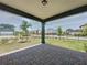 Covered patio with brick pavers offers outdoor living space and a view of the landscaped front yard and neighborhood at 6514 Barnstorm Way, St Cloud, FL 34771