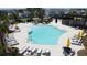 Aerial view of a resort-style community pool with lounge chairs, umbrellas, and a covered pavilion at 6514 Barnstorm Way, St Cloud, FL 34771