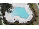 An aerial view of a modern community pool, lined with lounge chairs, palm trees, and a shaded pavilion at 6514 Barnstorm Way, St Cloud, FL 34771