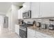 Kitchen with stainless steel appliances, light colored cabinets, and complementing granite countertops at 7211 Oakmoss Loop, Davenport, FL 33837