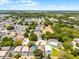 Sweeping aerial perspective of a neighborhood near a scenic lake featuring an expansive green space and mature trees at 829 Clear Creek Cir, Clermont, FL 34714