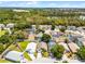Aerial view of a home with a beautiful backyard, in-ground pool, and the community surrounded by lush green trees at 829 Clear Creek Cir, Clermont, FL 34714