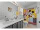 Bright bathroom featuring a double sink vanity with modern countertops and a fun Mickey Mouse themed shower curtain at 829 Clear Creek Cir, Clermont, FL 34714