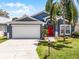 Lovely single-Gathering home with a two-car garage, red front door, and well-manicured lawn, creating a welcoming curb appeal at 829 Clear Creek Cir, Clermont, FL 34714