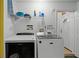 A well-equipped laundry room with modern washer and dryer, shelving for supplies, and convenient access to the exterior at 829 Clear Creek Cir, Clermont, FL 34714