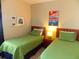 Comfortable twin bedroom featuring two beds, bedside table and colorful artwork at 8809 Dunes Ct # 201, Kissimmee, FL 34747