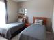 Clean bedroom featuring two twin beds, bedside table, and neutral decor at 8809 Dunes Ct # 201, Kissimmee, FL 34747