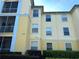 Exterior apartment building with balconies, hedges, and yellow siding at 8809 Dunes Ct # 201, Kissimmee, FL 34747