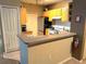 This kitchen features painted cabinets, modern appliances, and a convenient breakfast bar for quick meals at 8809 Dunes Ct # 201, Kissimmee, FL 34747
