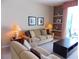 Comfortable living room featuring a plush sofa, decorative shelving, and neutral tones at 8809 Dunes Ct # 201, Kissimmee, FL 34747