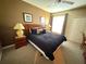 This comfortable main bedroom includes a ceiling fan, closet, and a sunny window with curtains at 8809 Dunes Ct # 201, Kissimmee, FL 34747