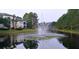 Picturesque community pond featuring a fountain, serene water, and lush greenery at 8809 Dunes Ct # 201, Kissimmee, FL 34747