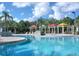 Serene pool area with colorful cabanas, palm trees, and crystal-clear water for relaxation and enjoyment at 8809 Dunes Ct # 201, Kissimmee, FL 34747